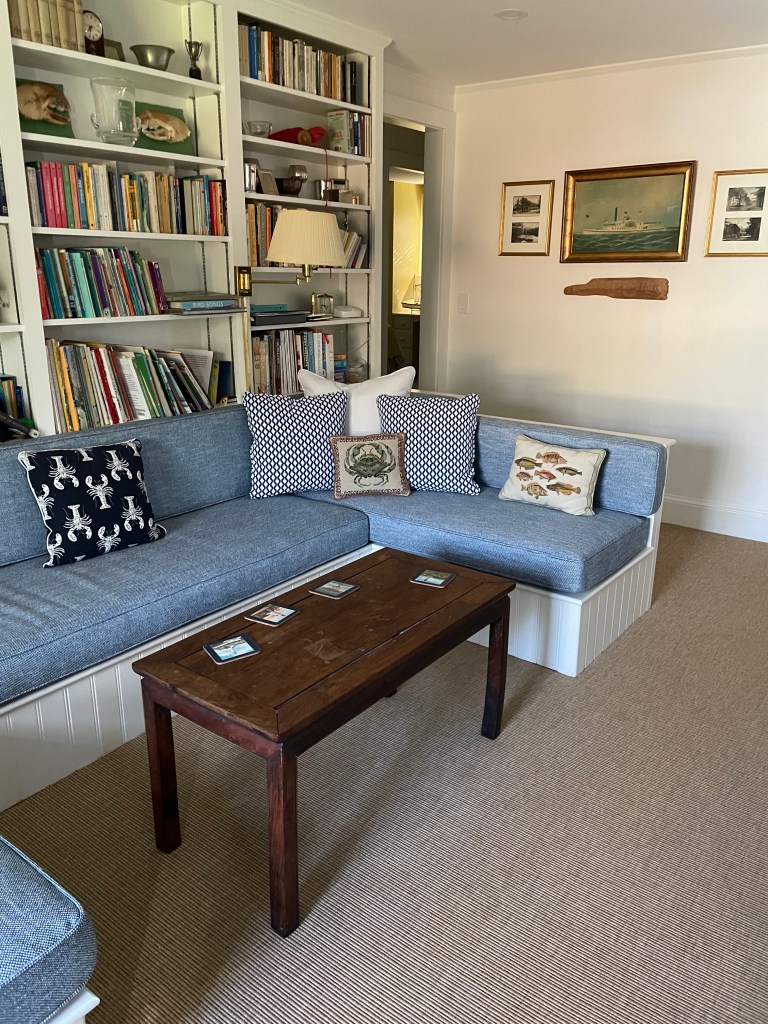 A nautical style room with custom pillows and slipcovers.